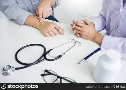 attractive Male doctor Examining discussing reports with Massage patient suffering from back pain in clinic