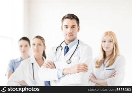 attractive male doctor in front of medical group