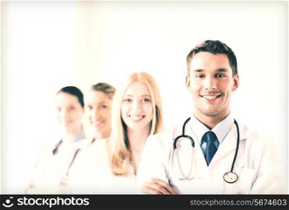 attractive male doctor in front of medical group
