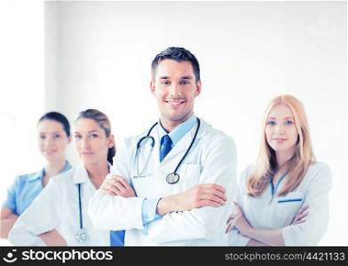 attractive male doctor in front of medical group. male doctor in front of medical group
