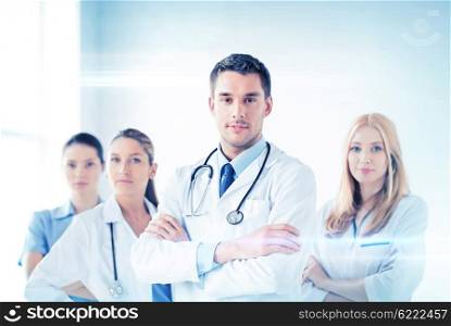 attractive male doctor in front of medical group. male doctor in front of medical group