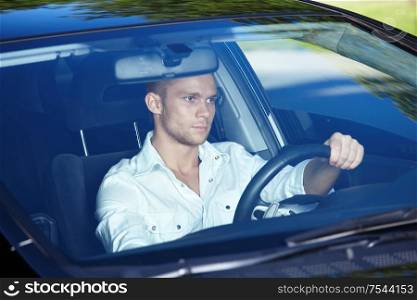 Attractive man behind the wheel of his car