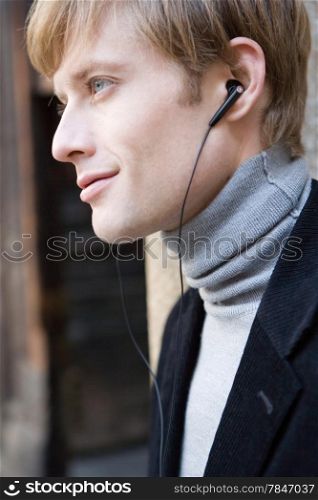 attractive man in urban background listening to the music