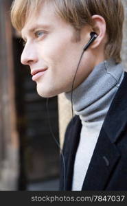 attractive man in urban background listening to the music