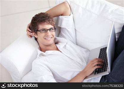 Attractive man with laptop on a couch