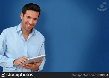 Attractive man with touchpad on blue background