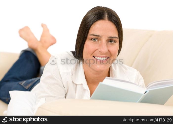 Attractive mid-aged woman read book on sofa in lounge
