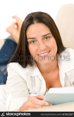 Attractive mid-aged woman read book on sofa in lounge