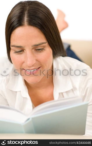 Attractive mid-aged woman read book on sofa in lounge