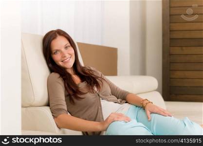 Attractive mid-aged woman relax modern living room on leather sofa