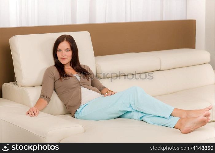 Attractive mid-aged woman relax modern living room on leather sofa