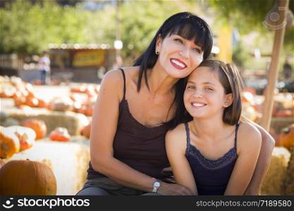 Attractive Mother and Baby Daughter Portrait in a Rustic Ranch Setting at the Pumpkin Patch.