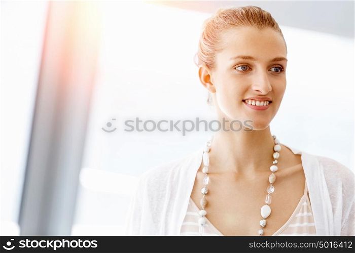 Attractive office worker portrait. Attractive woman in white in office
