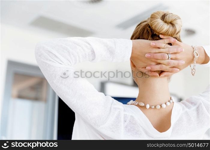 Attractive office worker sitting at desk. Attractive woman sitting at desk in office view from back