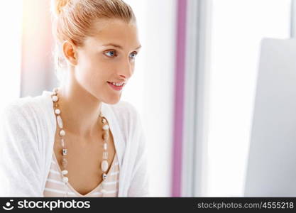 Attractive office worker sitting at desk. Attractive woman sitting at desk in office