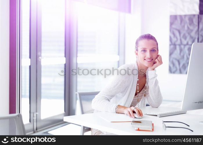 Attractive office worker sitting at desk. Attractive woman sitting at desk in office