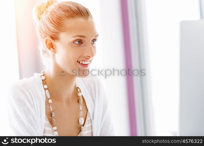 Attractive office worker sitting at desk. Attractive woman sitting at desk in office