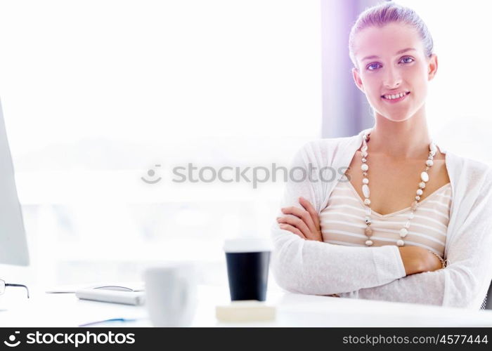 Attractive office worker sitting at desk. Attractive woman sitting at desk in office