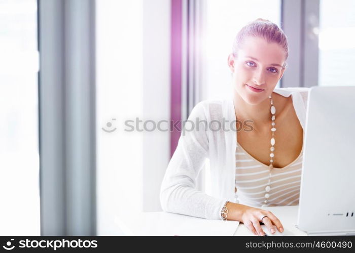 Attractive office worker sitting at desk. Attractive woman sitting at desk in office