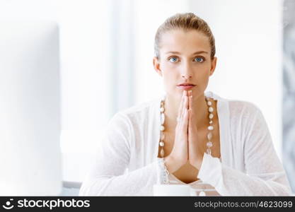 Attractive office worker sitting at desk. Attractive woman sitting at desk in office