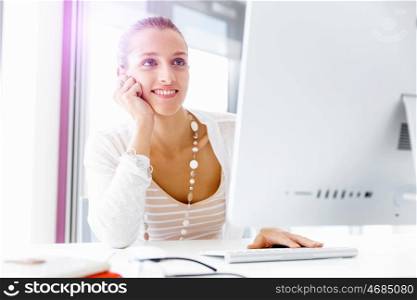 Attractive office worker sitting at desk. Attractive woman sitting at desk in office