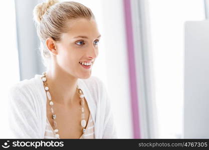 Attractive office worker sitting at desk. Attractive woman sitting at desk in office