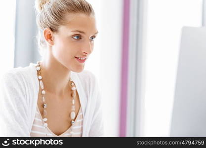 Attractive office worker sitting at desk. Attractive woman sitting at desk in office