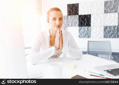 Attractive office worker sitting at desk. Attractive woman sitting at desk in office