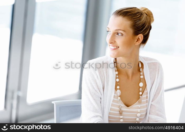 Attractive office worker sitting at desk. Attractive woman sitting at desk in office