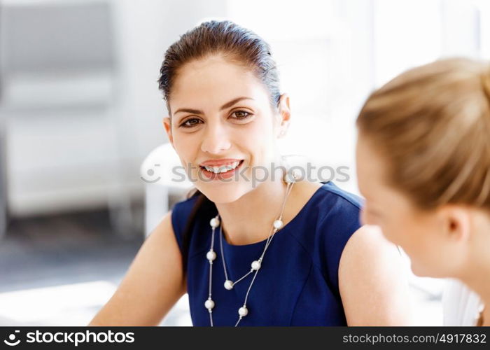 Attractive office worker sitting at desk. Attractive woman sitting at desk in office