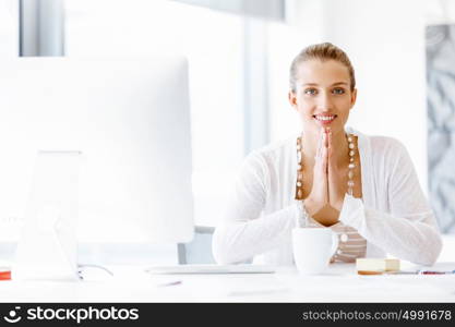 Attractive office worker sitting at desk. Attractive woman sitting at desk in office