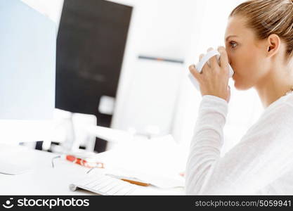 Attractive office worker sitting at desk. Attractive woman sitting at desk in office