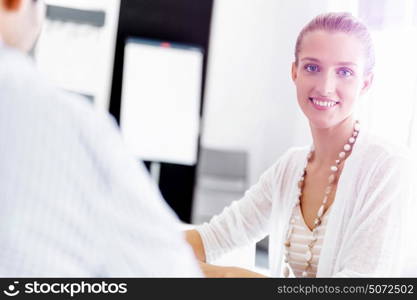 Attractive office worker sitting at desk. Attractive woman sitting at desk in office