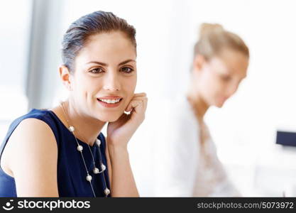 Attractive office worker sitting at desk. Attractive woman sitting at desk in office