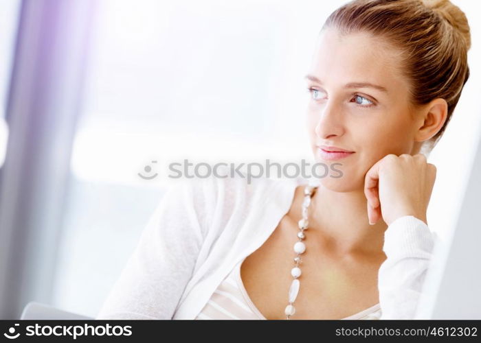 Attractive office worker sitting at desk. Attractive woman sitting at desk in office portrait