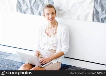 Attractive office worker sitting on floor. Attractive woman sitting on floor in office with notepad