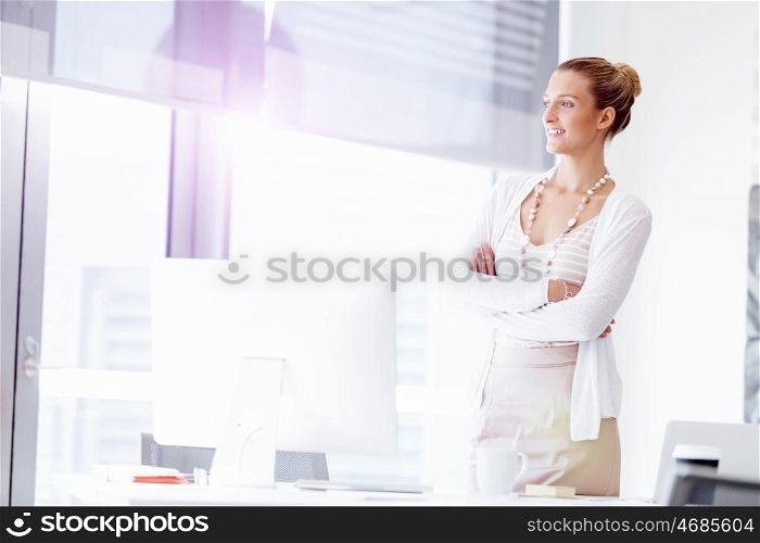 Attractive office worker standing. Attractive woman standing in office