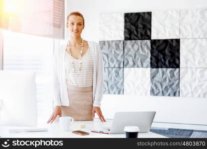 Attractive office worker standing. Attractive woman standing in office