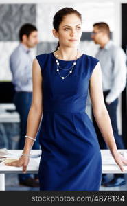 Attractive office worker standing. Attractive woman standing in office