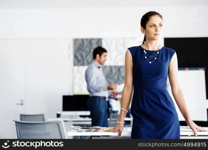 Attractive office worker standing. Attractive woman standing in office