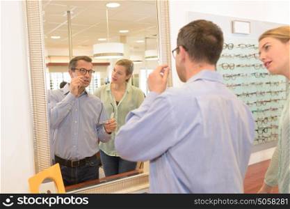 attractive optometrist and man choosing a new frames