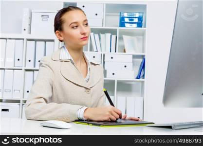 Attractive photo editor working on computer in a modern office. Designer at work