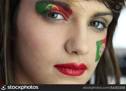 Attractive Portuguese woman with national flag painted on face