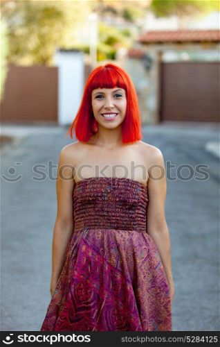 Attractive red hair woman with a beautiful dress in the street