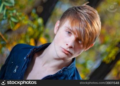 attractive, red-haired guy on nature. close-up portrait