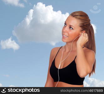 Attractive runner girl listening music with a blue sky of background