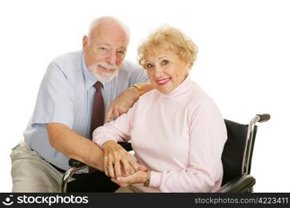 Attractive senior couple - the wife is in a wheelchair. Isolated on white.
