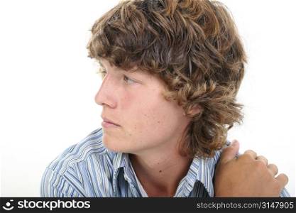 Attractive Sixteen Year Old Teen Boy in casual over white background. Light brown curly hair and hazel eyes.