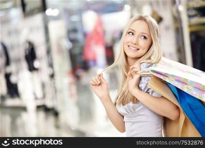 Attractive smiling blonde on shopping in shop