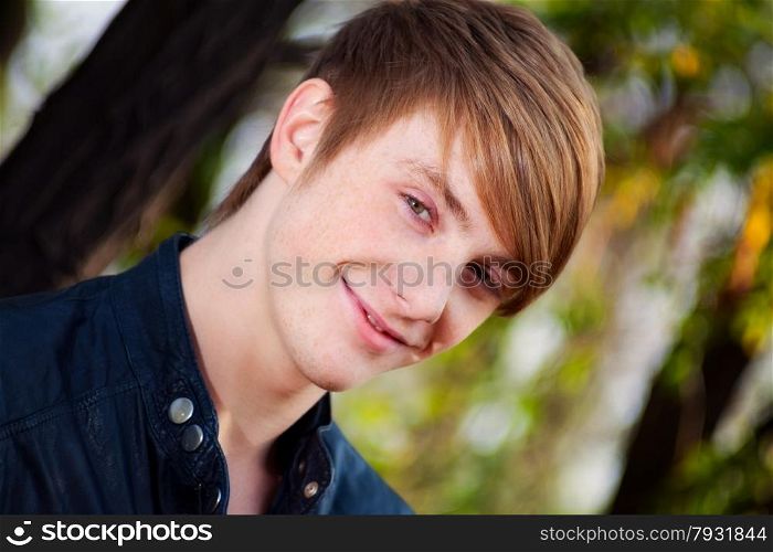 attractive, smiling, red-haired guy on nature. close-up portrait